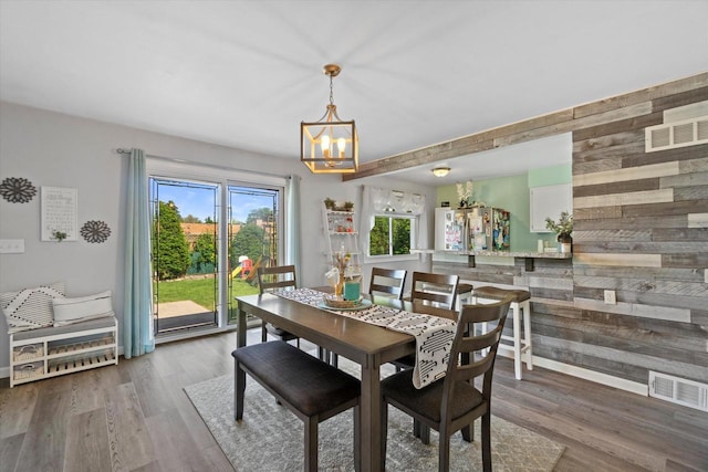 3433 Illinois St, Mount Pleasant, WI 53405 - dining area with wood walls, a chandelier, wood finished floors, and baseboards