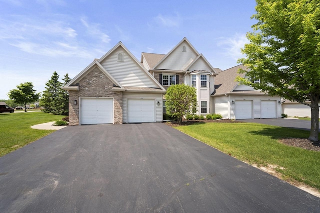 1820 Stoney Ln, Slinger, WI 53086 - view of front of house featuring driveway, a front lawn, and an attached garage