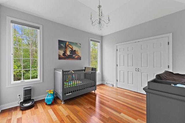 4205 Quarry Springs Dr, Racine, WI 53405 - bedroom featuring a chandelier, wood finished floors, baseboards, a closet, and a nursery area