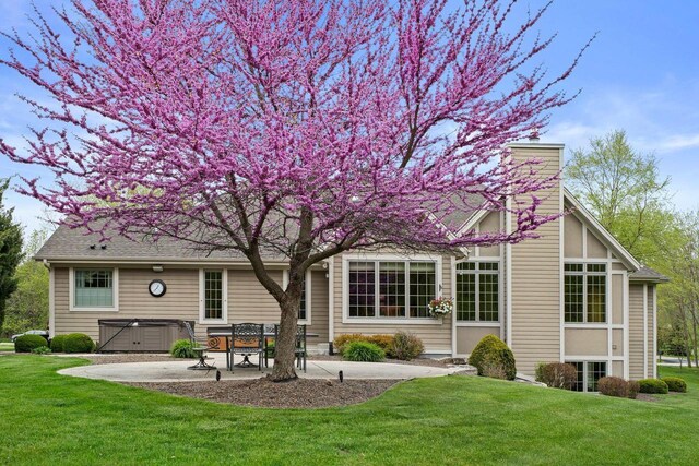 4205 Quarry Springs Dr, Racine, WI 53405 - back of property featuring a hot tub, a patio, a chimney, and a lawn