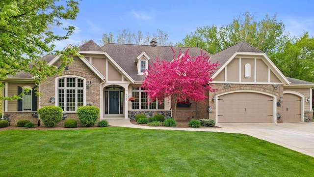 4205 Quarry Springs Dr, Racine, WI 53405 - tudor-style house with an attached garage, concrete driveway, and stone siding
