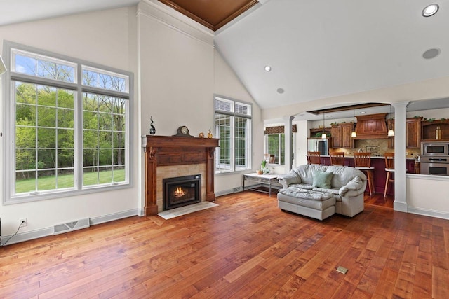 4205 Quarry Springs Dr, Racine, WI 53405 - living room featuring ornate columns, high vaulted ceiling, hardwood / wood-style flooring, a fireplace with flush hearth, and recessed lighting