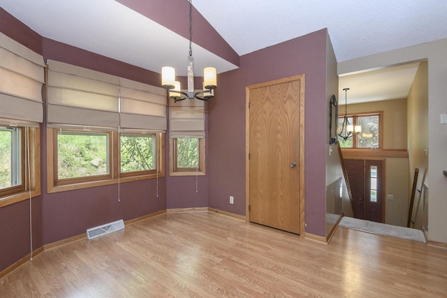 1915 Bonnie Ln, Waukesha, WI 53188 - spare room with a chandelier, wood finished floors, plenty of natural light, and baseboards