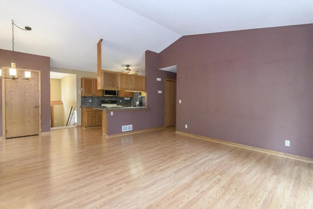 1915 Bonnie Ln, Waukesha, WI 53188 - kitchen featuring light wood-type flooring, stainless steel microwave, lofted ceiling, range, and open floor plan