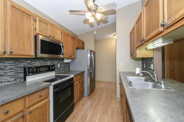 1915 Bonnie Ln, Waukesha, WI 53188 - kitchen featuring stainless steel appliances, a sink, light wood-type flooring, ceiling fan, and tasteful backsplash