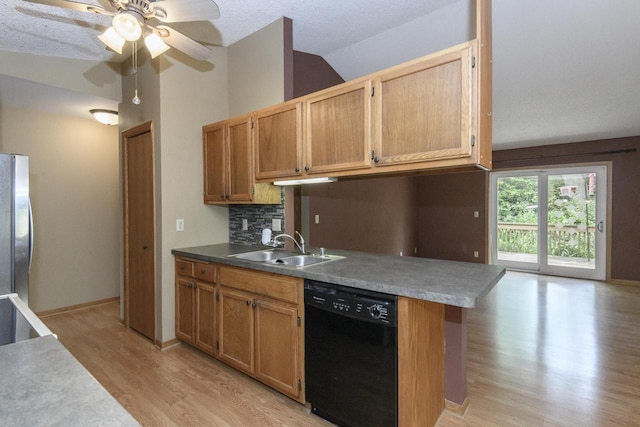 1915 Bonnie Ln, Waukesha, WI 53188 - kitchen featuring black dishwasher, a sink, light wood-style flooring, freestanding refrigerator, and lofted ceiling