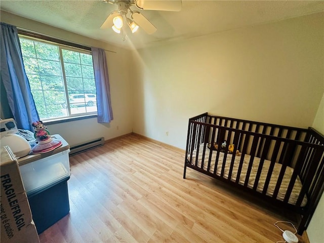 W14440 Culver Ave, Weyerhaeuser, WI 54895 - bedroom with baseboard heating, wood finished floors, a ceiling fan, and baseboards