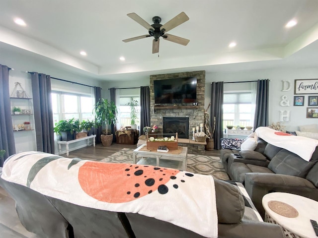110 Grand St, Highland, WI 53543 - living room with a raised ceiling, a ceiling fan, a stone fireplace, wood finished floors, and recessed lighting