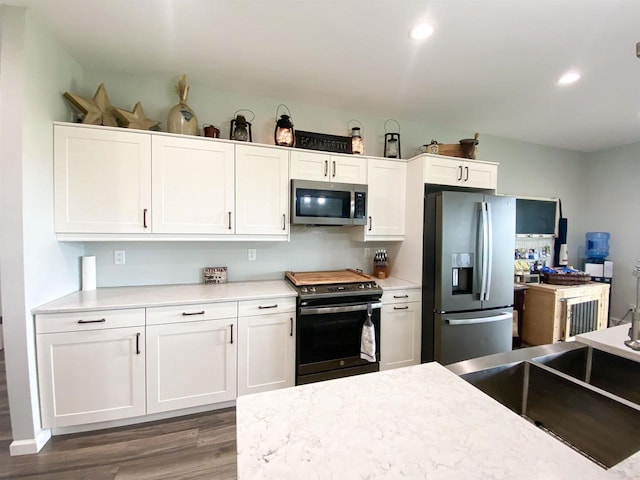 110 Grand St, Highland, WI 53543 - kitchen featuring appliances with stainless steel finishes, wood finished floors, white cabinets, and recessed lighting