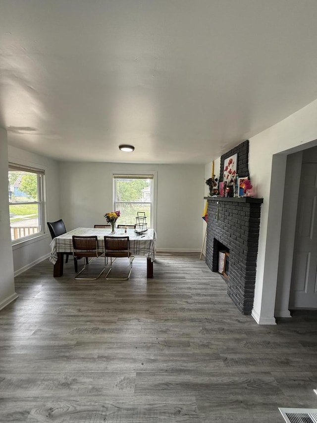 2667 N 36th St, Milwaukee, WI 53210 - dining room with baseboards, plenty of natural light, a brick fireplace, and wood finished floors