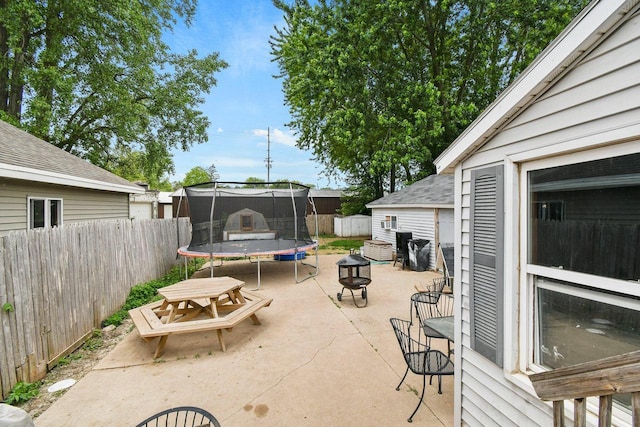 324 N Lincoln Ave, Beaver Dam, WI 53916 - fenced backyard with a trampoline, a patio area, a fire pit, and outdoor dining area