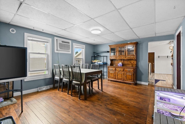 324 N Lincoln Ave, Beaver Dam, WI 53916 - dining space featuring a drop ceiling, dark wood-style flooring, and an AC wall unit