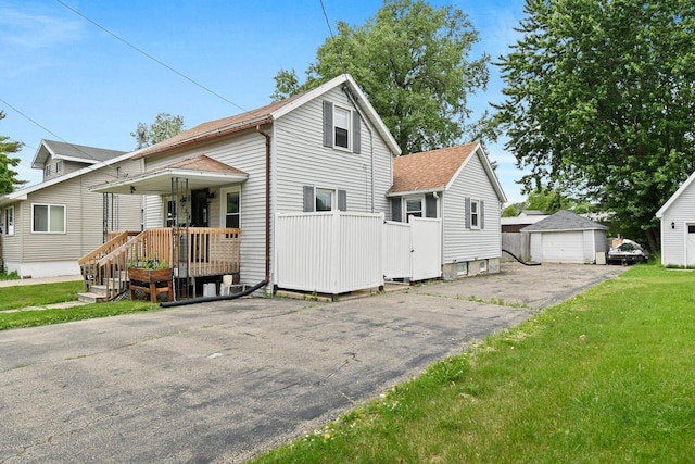 324 N Lincoln Ave, Beaver Dam, WI 53916 - view of front facade featuring a detached garage, roof with shingles, and a front lawn