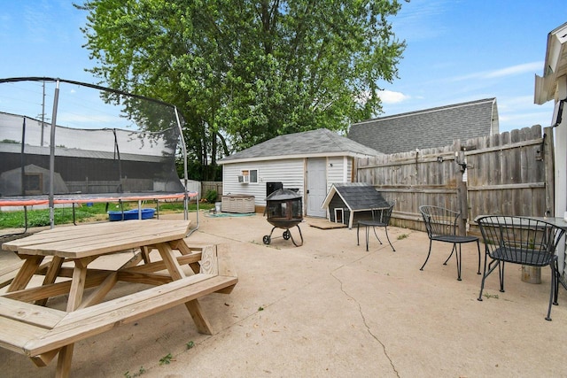 324 N Lincoln Ave, Beaver Dam, WI 53916 - fenced backyard with a trampoline, a patio area, a storage unit, and outdoor dining area