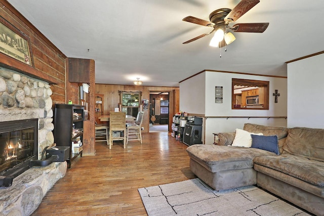 2518 Borg Rd, Delavan, WI 53115 - living area featuring crown molding, ceiling fan, wood finished floors, a fireplace, and wooden walls