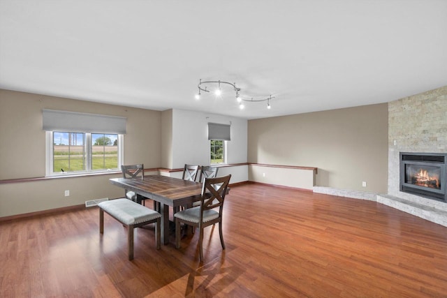 6650 N 114th St, Milwaukee, WI 53224 - dining room featuring wood finished floors, a fireplace, track lighting, and baseboards