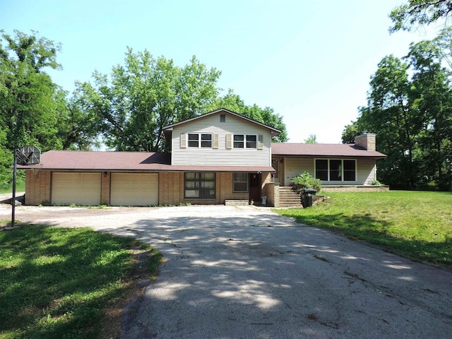 422 E Catherine St, Muscoda, WI 53573 - tri-level home featuring driveway, an attached garage, a chimney, a front yard, and brick siding