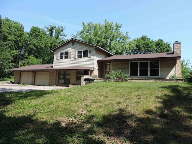 422 E Catherine St, Muscoda, WI 53573 - tri-level home with an attached garage, a chimney, a front yard, and brick siding