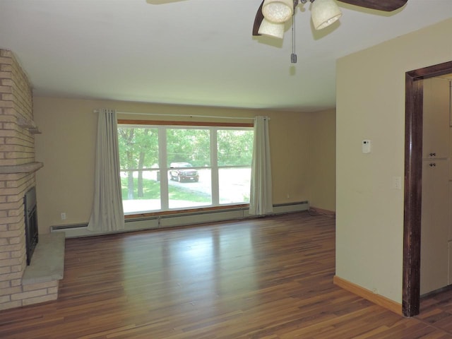 422 E Catherine St, Muscoda, WI 53573 - unfurnished living room featuring ceiling fan, a baseboard radiator, wood finished floors, a brick fireplace, and baseboards