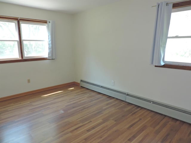422 E Catherine St, Muscoda, WI 53573 - empty room featuring a baseboard heating unit, wood finished floors, and baseboards