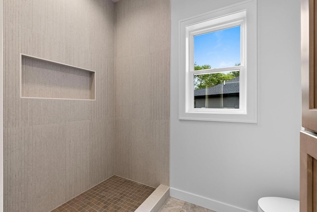 3566 W Hank Ave, De Pere, WI 54115 - bathroom featuring toilet, a tile shower, and baseboards