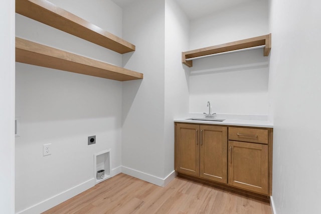 3566 W Hank Ave, De Pere, WI 54115 - laundry room with hookup for an electric dryer, light wood-type flooring, bar with sink, baseboards, and cabinet space