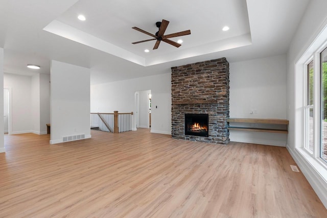 3566 W Hank Ave, De Pere, WI 54115 - unfurnished living room with a raised ceiling, ceiling fan, light wood-style floors, recessed lighting, and baseboards