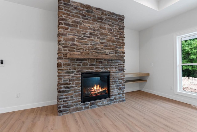 3566 W Hank Ave, De Pere, WI 54115 - unfurnished living room featuring wood finished floors, baseboards, and a stone fireplace