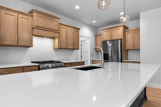 3566 W Hank Ave, De Pere, WI 54115 - kitchen featuring stainless steel appliances, a sink, light countertops, decorative light fixtures, and light wood-type flooring