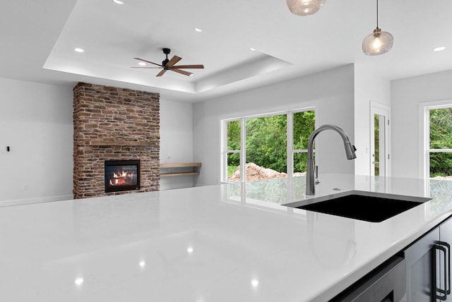 3566 W Hank Ave, De Pere, WI 54115 - kitchen featuring light countertops, a sink, recessed lighting, a tray ceiling, and ceiling fan