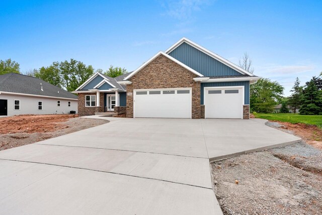 3566 W Hank Ave, De Pere, WI 54115 - craftsman inspired home featuring concrete driveway, board and batten siding, a garage, and stone siding