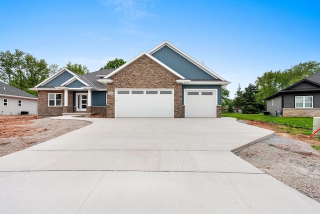 3566 W Hank Ave, De Pere, WI 54115 - craftsman-style house featuring an attached garage, board and batten siding, concrete driveway, and stone siding