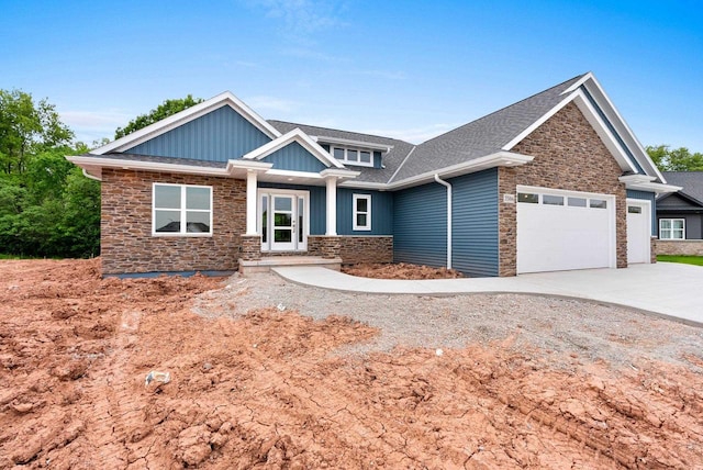 3566 W Hank Ave, De Pere, WI 54115 - craftsman inspired home featuring stone siding, a garage, driveway, board and batten siding, and roof with shingles