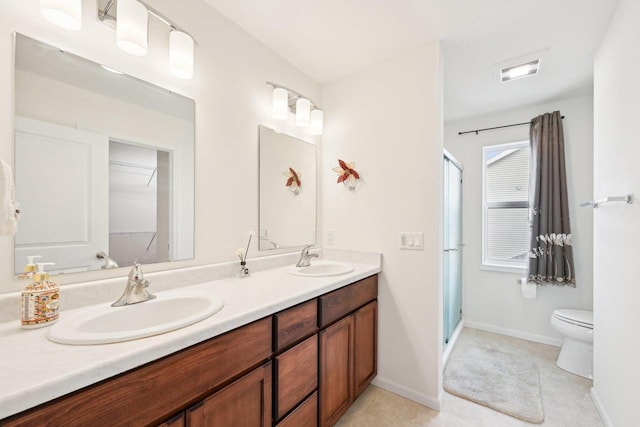 2418 Leopold Way, Sun Prairie, WI 53590 - bathroom with a stall shower, double vanity, toilet, baseboards, and tile patterned flooring