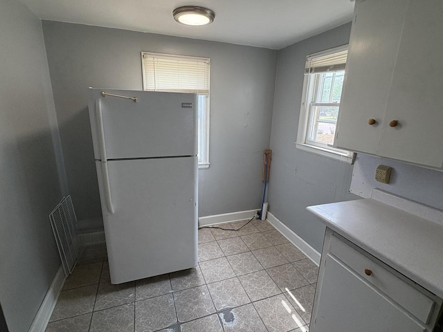 230 Park Ave, Wisconsin Rapids, WI 54495 - kitchen with freestanding refrigerator, light tile patterned floors, baseboards, light countertops, and white cabinets