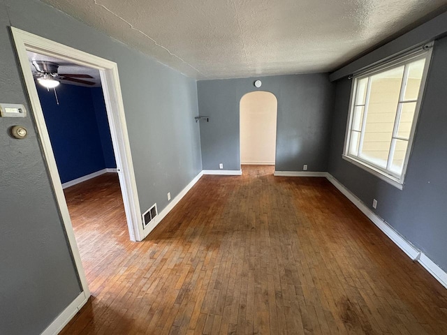 230 Park Ave, Wisconsin Rapids, WI 54495 - unfurnished room with arched walkways, wood-type flooring, a textured ceiling, baseboards, and ceiling fan