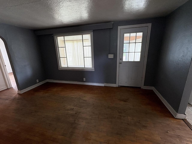 230 Park Ave, Wisconsin Rapids, WI 54495 - foyer featuring arched walkways, dark wood-style floors, a textured ceiling, and baseboards
