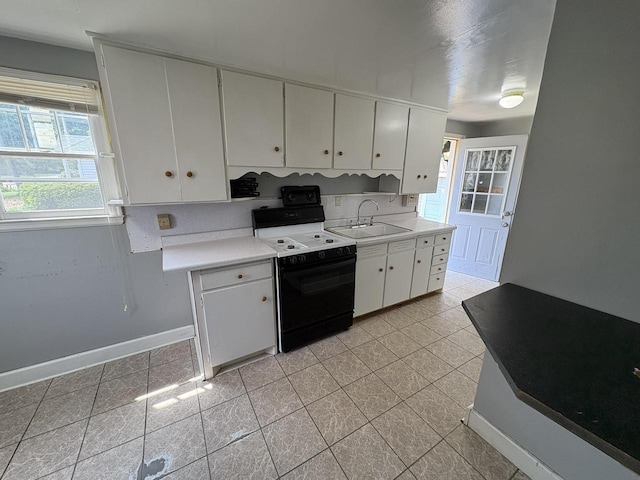 230 Park Ave, Wisconsin Rapids, WI 54495 - kitchen featuring electric range, a sink, light countertops, white cabinets, and baseboards