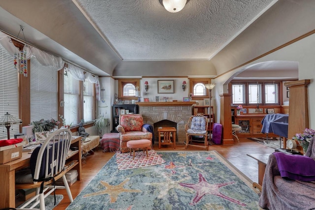 1107 S 71st St Unit 1109, West Allis, WI 53214 - living area featuring arched walkways, a textured ceiling, a fireplace, wood finished floors, and ornamental molding