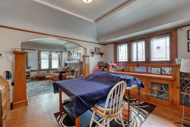 1107 S 71st St Unit 1109, West Allis, WI 53214 - dining space with arched walkways, hardwood / wood-style floors, a textured ceiling, ornamental molding, and a tray ceiling