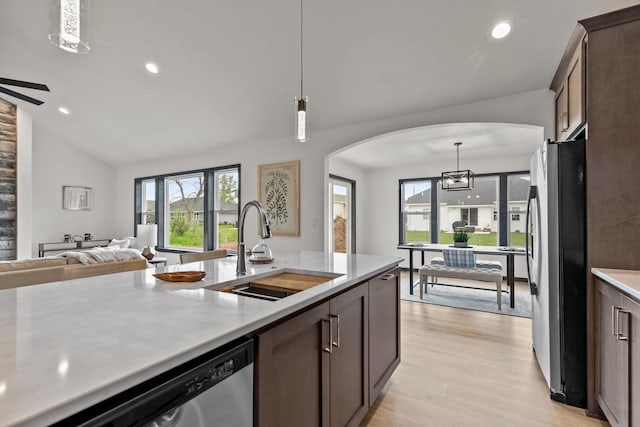 1338 Highland Ridge Dr, De Pere, WI 54115 - kitchen with a sink, arched walkways, stainless steel appliances, dark brown cabinetry, and light countertops