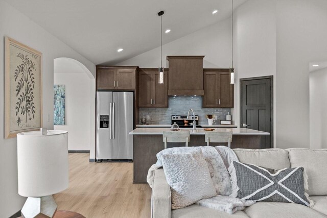 1338 Highland Ridge Dr, De Pere, WI 54115 - kitchen with stainless steel appliances, light countertops, dark brown cabinetry, light wood-style flooring, and tasteful backsplash