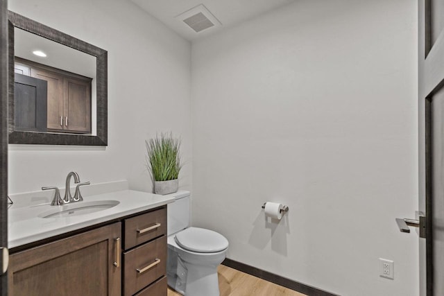 1338 Highland Ridge Dr, De Pere, WI 54115 - half bath with toilet, vanity, wood finished floors, and baseboards