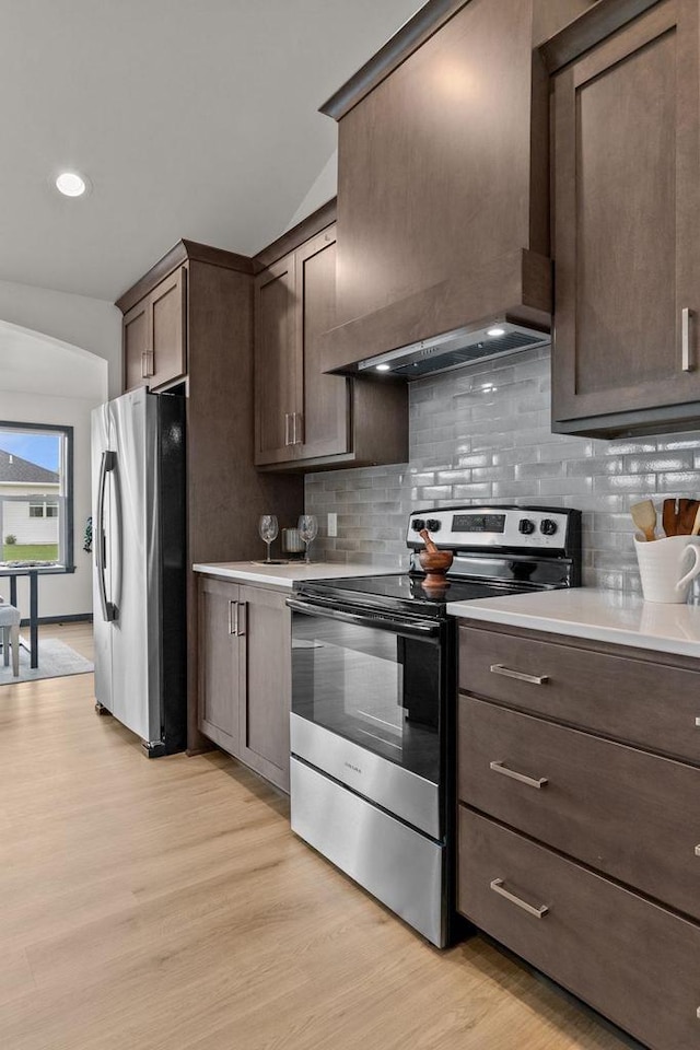 1338 Highland Ridge Dr, De Pere, WI 54115 - kitchen featuring stainless steel appliances, custom range hood, dark brown cabinetry, light wood-style flooring, and light countertops