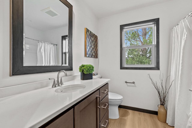 1338 Highland Ridge Dr, De Pere, WI 54115 - full bath with vanity, wood finished floors, toilet, baseboards, and a shower with shower curtain