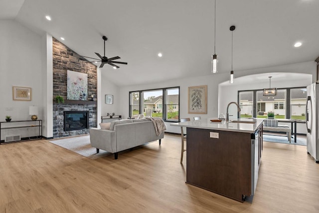 1338 Highland Ridge Dr, De Pere, WI 54115 - kitchen featuring a ceiling fan, light wood-type flooring, light countertops, an island with sink, and arched walkways