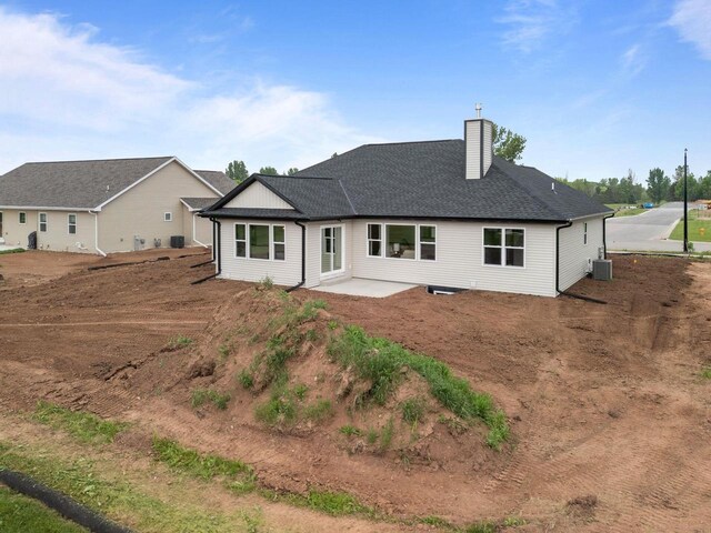 1338 Highland Ridge Dr, De Pere, WI 54115 - back of house featuring a chimney, a patio area, cooling unit, and roof with shingles
