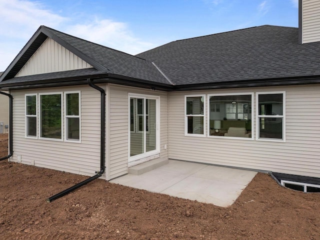 1338 Highland Ridge Dr, De Pere, WI 54115 - rear view of house with roof with shingles, board and batten siding, a patio area, and a chimney