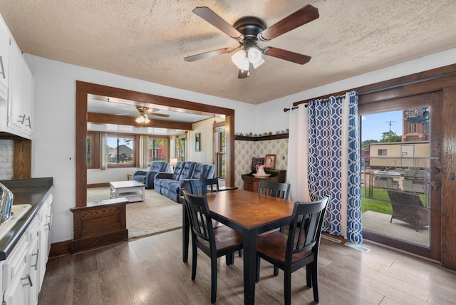 1439 Parkview Dr, Kewaskum, WI 53040 - dining area with a ceiling fan, wood finished floors, a textured ceiling, and baseboards
