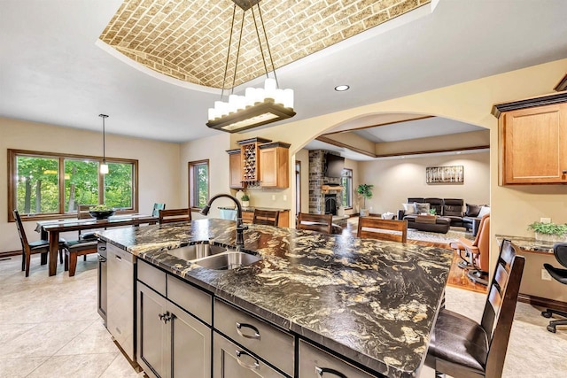 1830 Pine Tree Ct, Luxemburg, WI 54217 - kitchen featuring a sink, arched walkways, a tray ceiling, stainless steel dishwasher, and pendant lighting